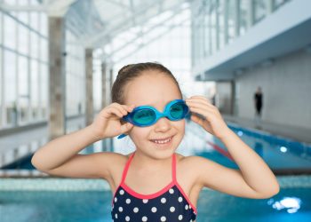 Happy little swimmer in modern pool